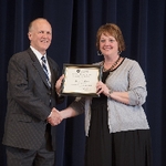 Doctor Potteiger posing for a photo with an award recipient in a black dress and grey sweater